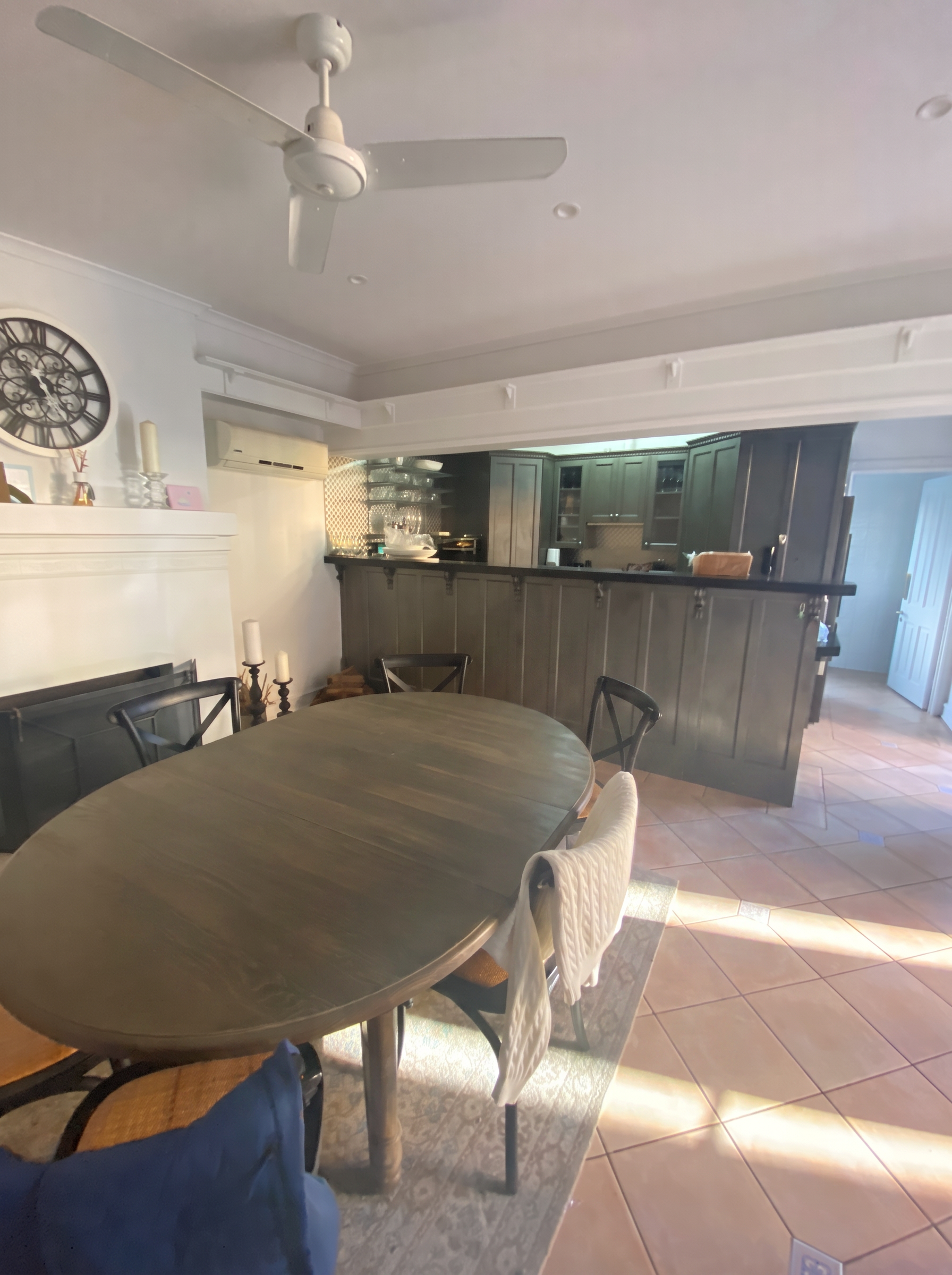 Uhlman Residence dining and kitchen area before renovation, with dark cabinetry and terracotta tiled floor