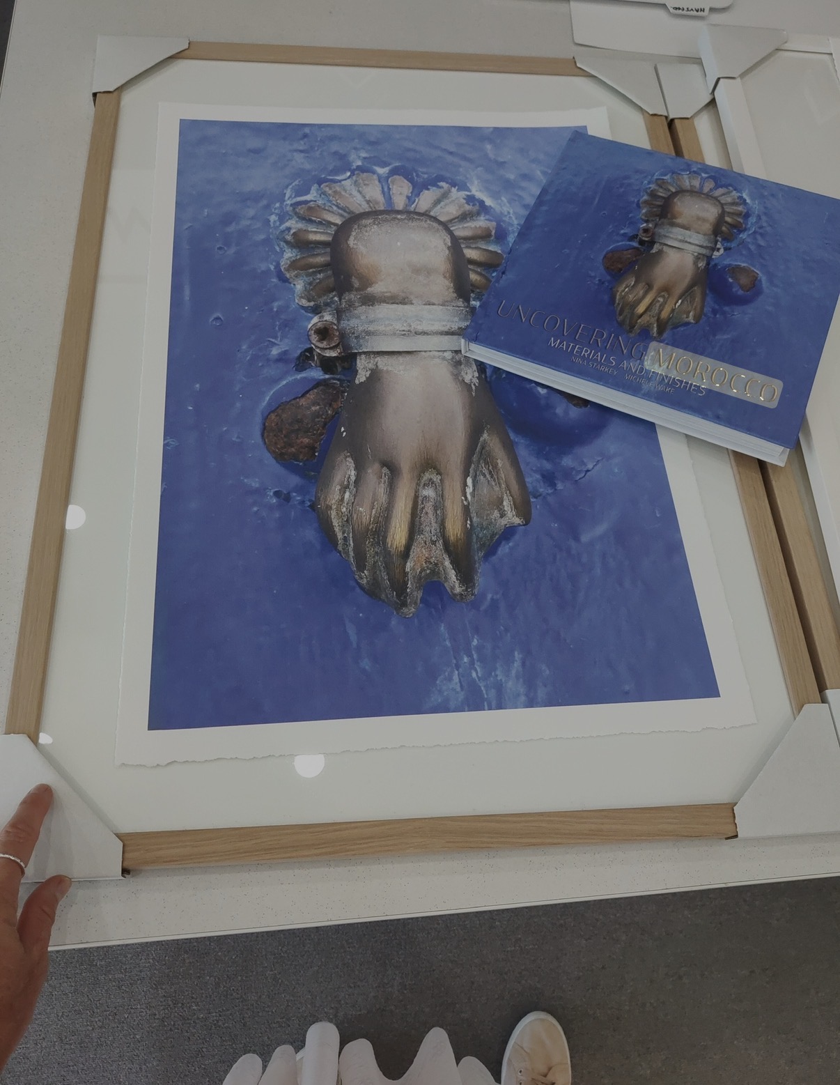 Framed Marrakesh hand of Fatima print alongside the Uncovering Morocco book