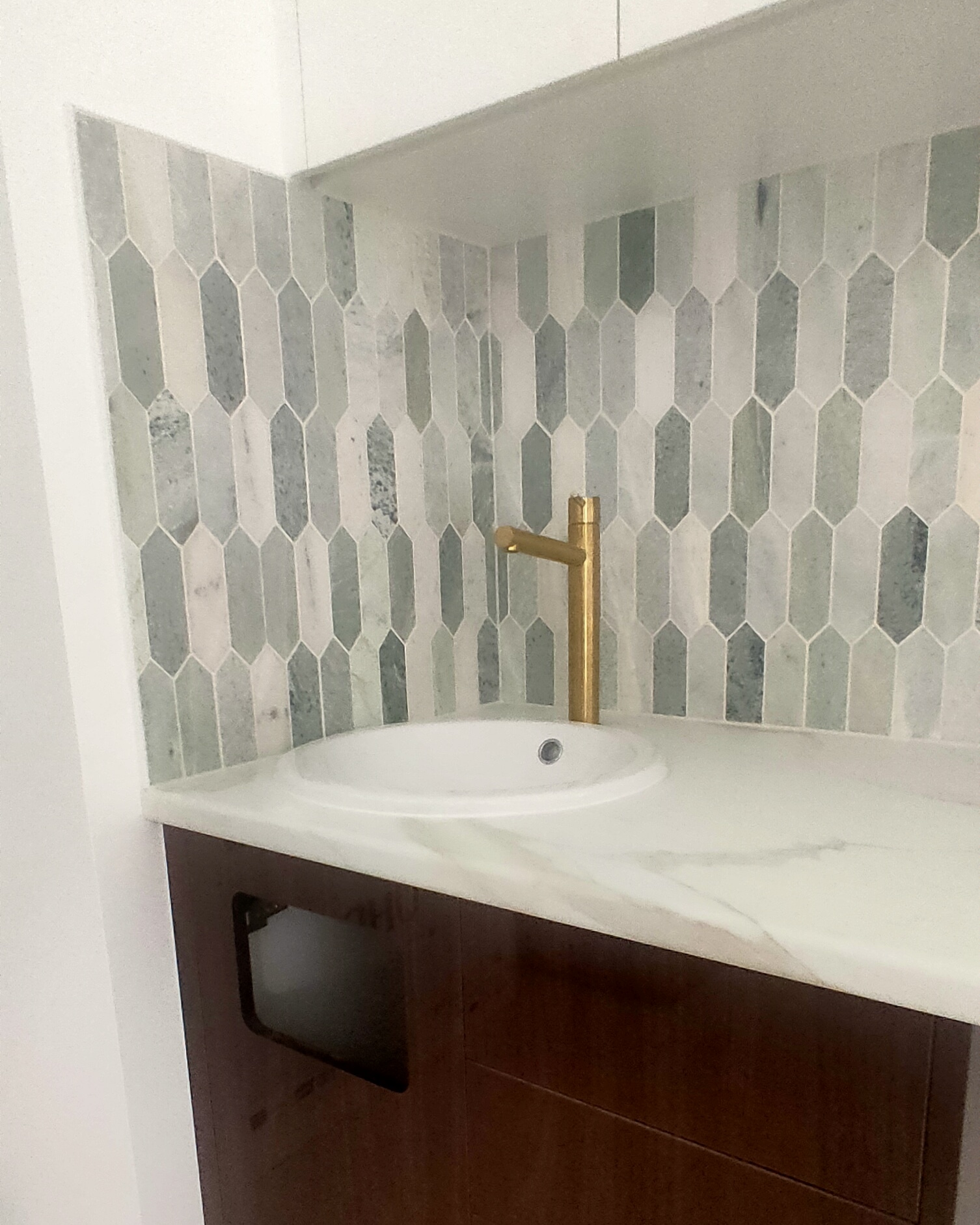 Wired Orthodontics treatment room basins with custom green tile and brass tapware